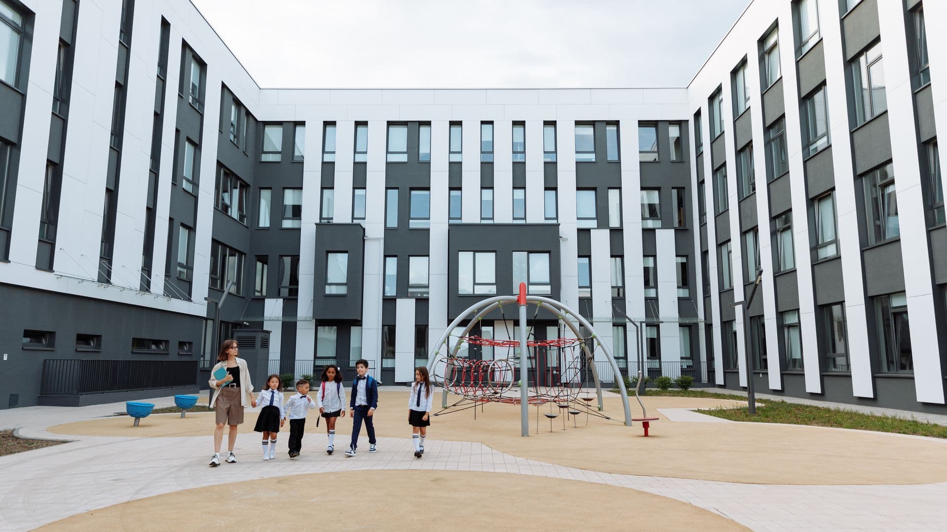 Modern school campus building with students in the courtyard