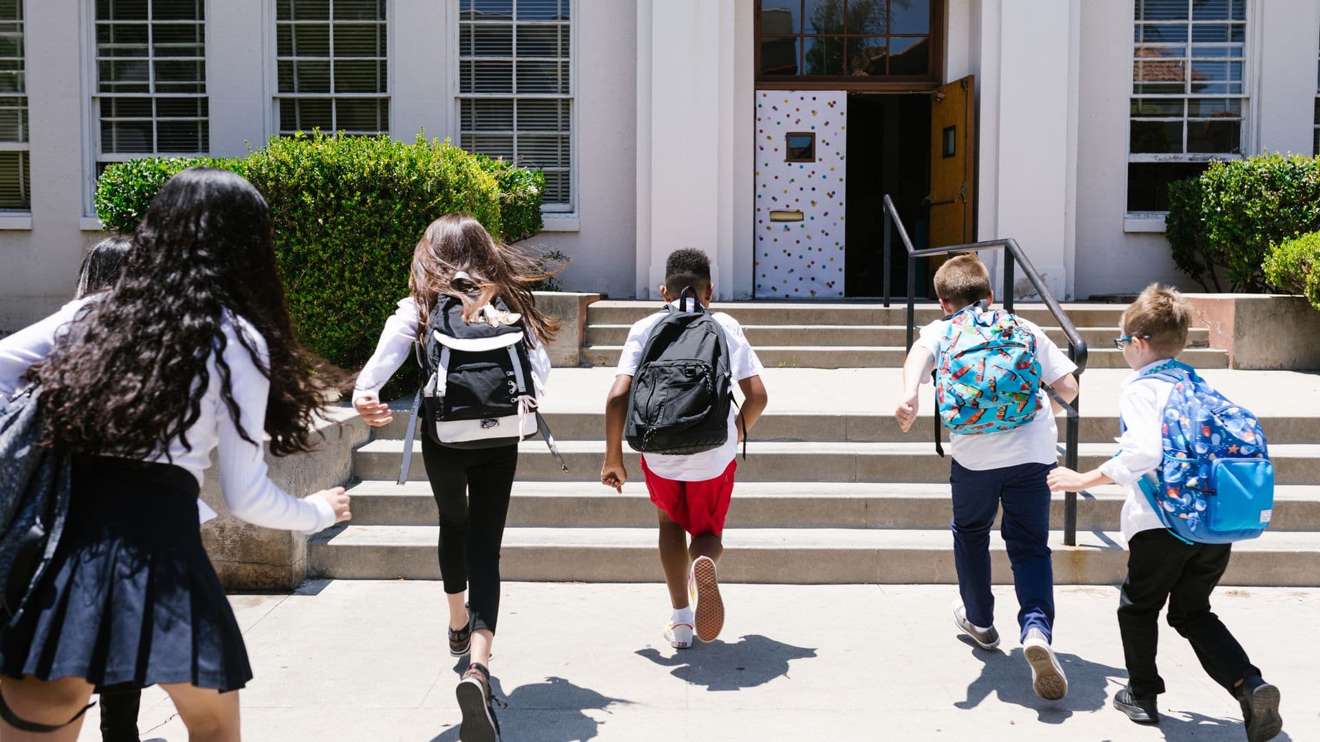 Students with backpacks heading into school